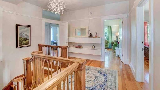 A spacious interior with a wooden staircase, a chandelier, and a view into another room. - Casa Bella Estate in Wine Country w/ New Pool! (Kenwood)