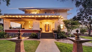 A two-story house with a covered front porch, a central entrance, and two stone fountains. - Casa Bella Estate in Wine Country w/ New Pool! (Kenwood)