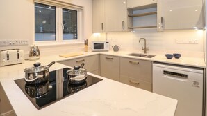 Eine moderne Küche mit Einbauherd, Mikrowelle und Geschirrspüler.