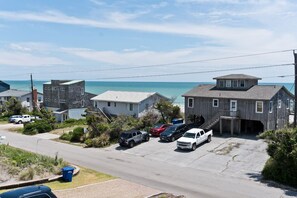 A coastal residential area with houses, a parking lot, and a view of the ocean. - Cardinal's Landing, Almost Oceanfront House in Emerald Isle, NC! (Emerald Isle)