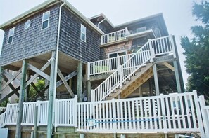 A multi-story house with a wooden deck and white railings. - Carolina Conch House, Almost Oceanfront House in Emerald Isle, NC! (Emerald Isle)