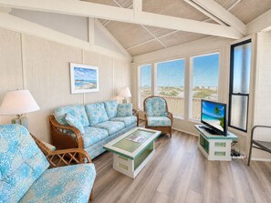 A living room with a sofa, two armchairs, a coffee table, and a television. - Carousel, Oceanfront House in Emerald Isle, NC! (Emerald Isle)