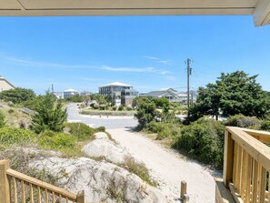 A coastal property with a sandy driveway leading to a house with a large balcony. - Carousel, Oceanfront House in Emerald Isle, NC! (Emerald Isle)