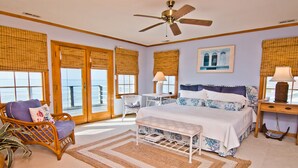 A bedroom with a bed, a chair, a desk, and a window with a view of the ocean. - Casa Atlantica, Oceanfront House in Pine Knoll Shores, NC! (Pine Knoll Shores)