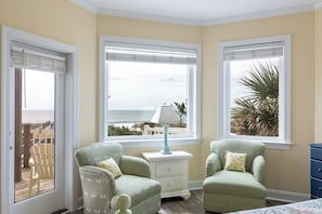 A room with two armchairs, a nightstand, and a view of the ocean. - Casa Del Sole, Oceanfront House in Emerald Isle, NC! (Emerald Isle)