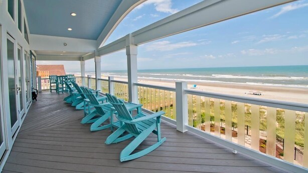 A covered deck with rocking chairs overlooking a beach. - Compass Pointe, Oceanfront House in Emerald Isle, NC! (Emerald Isle)