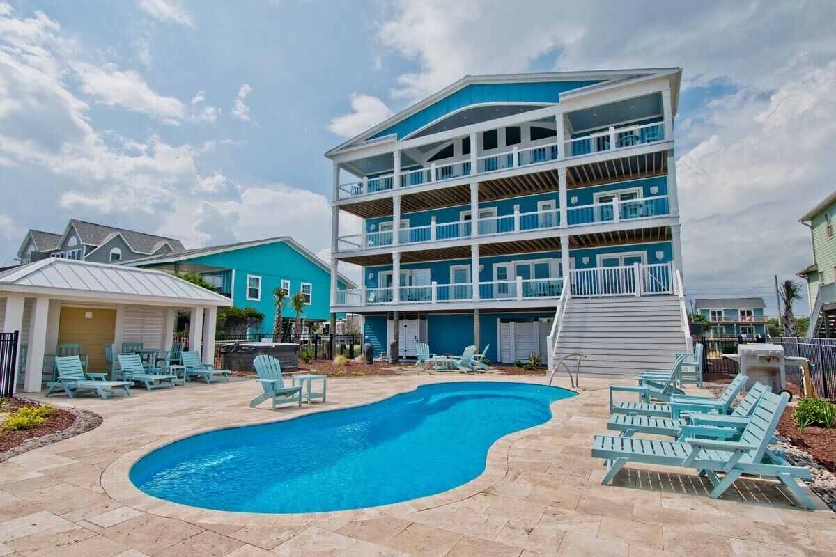 A multi-story building with a pool and outdoor seating area.