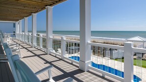Eine überdachte Terrasse mit Blick auf Strand und Meer.