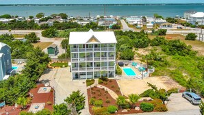 Un hôtel doté d’une piscine, entouré de verdure et offrant une vue sur la mer.