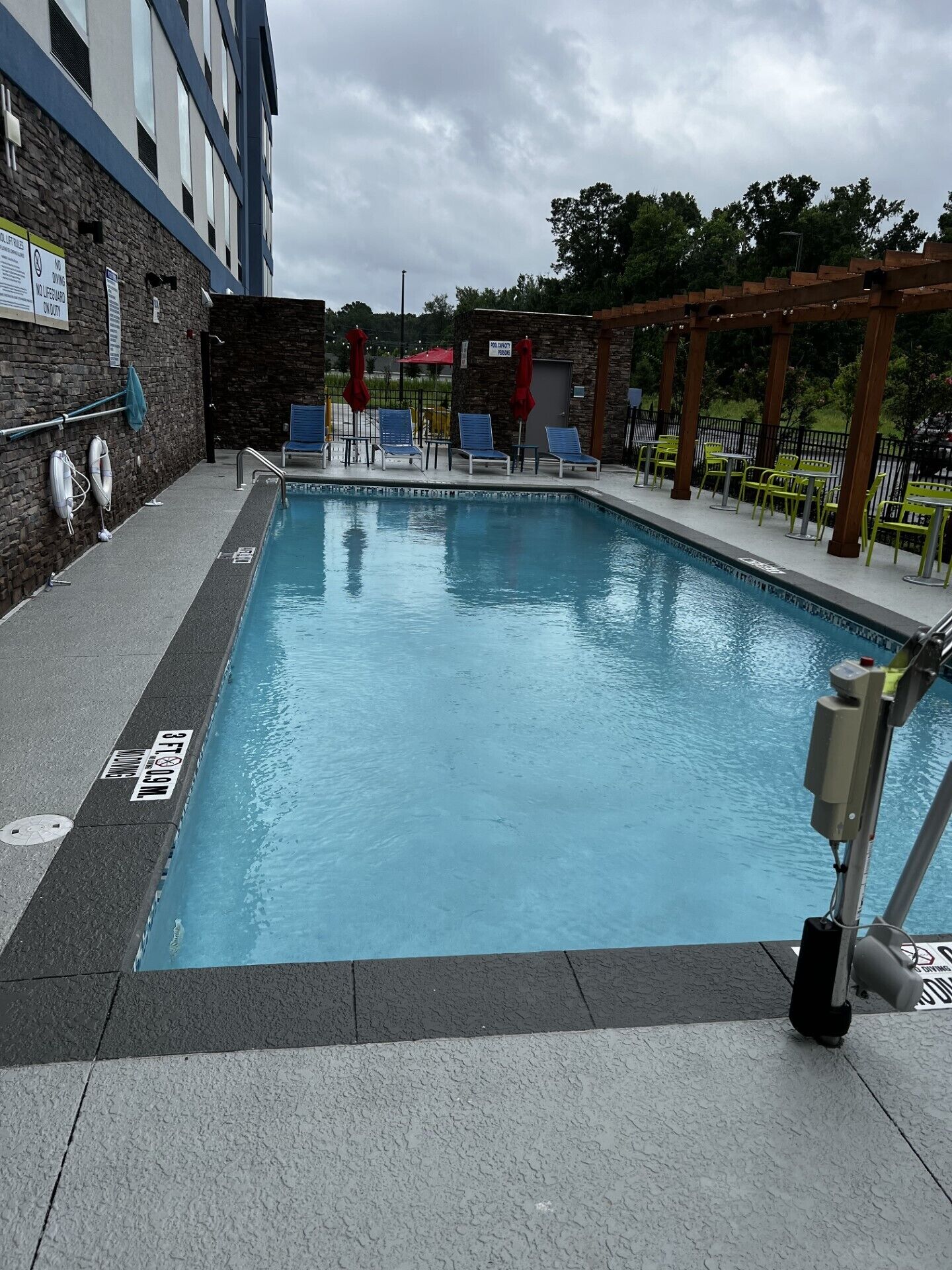 Piscina com espreguiçadeiras e posto de salva-vidas.