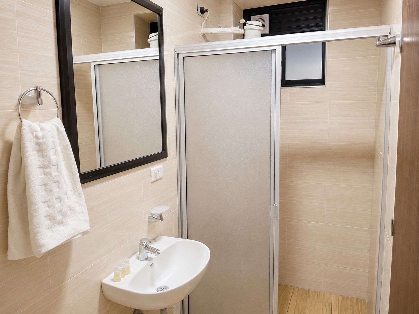 A bathroom with a white sink, a towel rack, and a mirror.