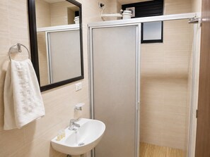 A bathroom with a white sink, a towel rack, and a mirror.