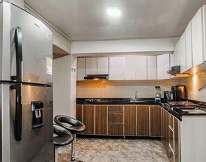 Fridge, microwave, cookware/dishes/utensils, dining tables - Double/Triple Suite 18-103 (Bogotá)