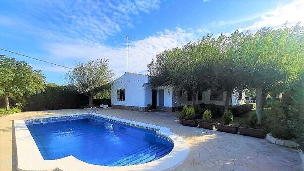 A swimming pool with a stone deck, surrounded by trees and a small white building. - SAONA VILLAS (VN CUAD): villa for 8 people, private pool, wifi (Tres Calas)