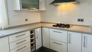 A modern kitchen with white cabinets, a gas stove, and a stainless steel range hood. - SAONA VILLAS (VN CUAD): villa for 8 people, private pool, wifi (Tres Calas)