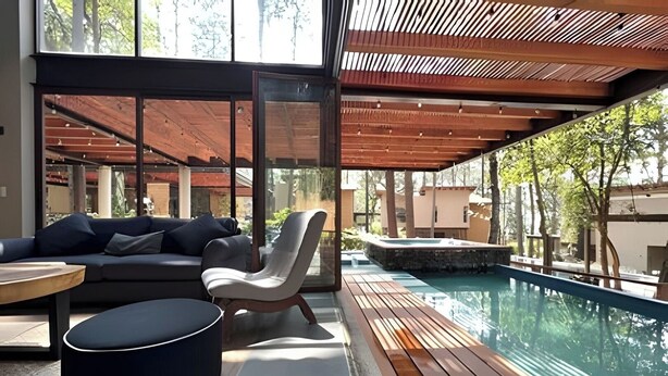 A modern outdoor seating area with a pool, wooden deck, and a covered section with a view of the pool. - Vacation house with private pool and hottub (Valle de Bravo)