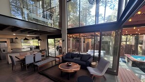 A modern open-plan living space with a kitchen, dining area, and a poolside seating area. - Vacation house with private pool and hottub (Valle de Bravo)