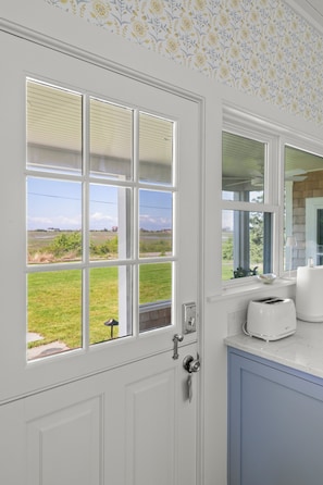 A kitchen with a window view, a toaster, and a cabinet.