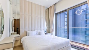 Ein modernes Schlafzimmer mit einem großen Bett, einem Schminktisch und einem großen Fenster mit Blick auf die Stadt.