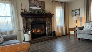 A cozy living room with a stone fireplace, a sofa, and a lamp.