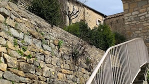 A stone staircase leading up to a building with a clock tower. - GITE AVEC TERRASSE  (Peyreleau)