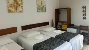 Une chambre d’hôtel avec deux lits, un bureau et une armoire.