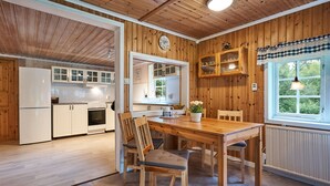 Un interno in legno con cucina, zona pranzo e una finestra vista.