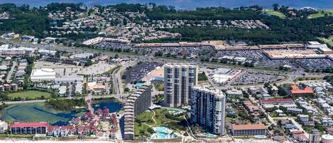 An aerial view of a coastal city with high-rise buildings, a marina, and a beach.