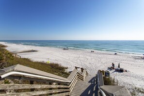 A beach with wooden boardwalks leading to the shore, sandy beach, and ocean view.