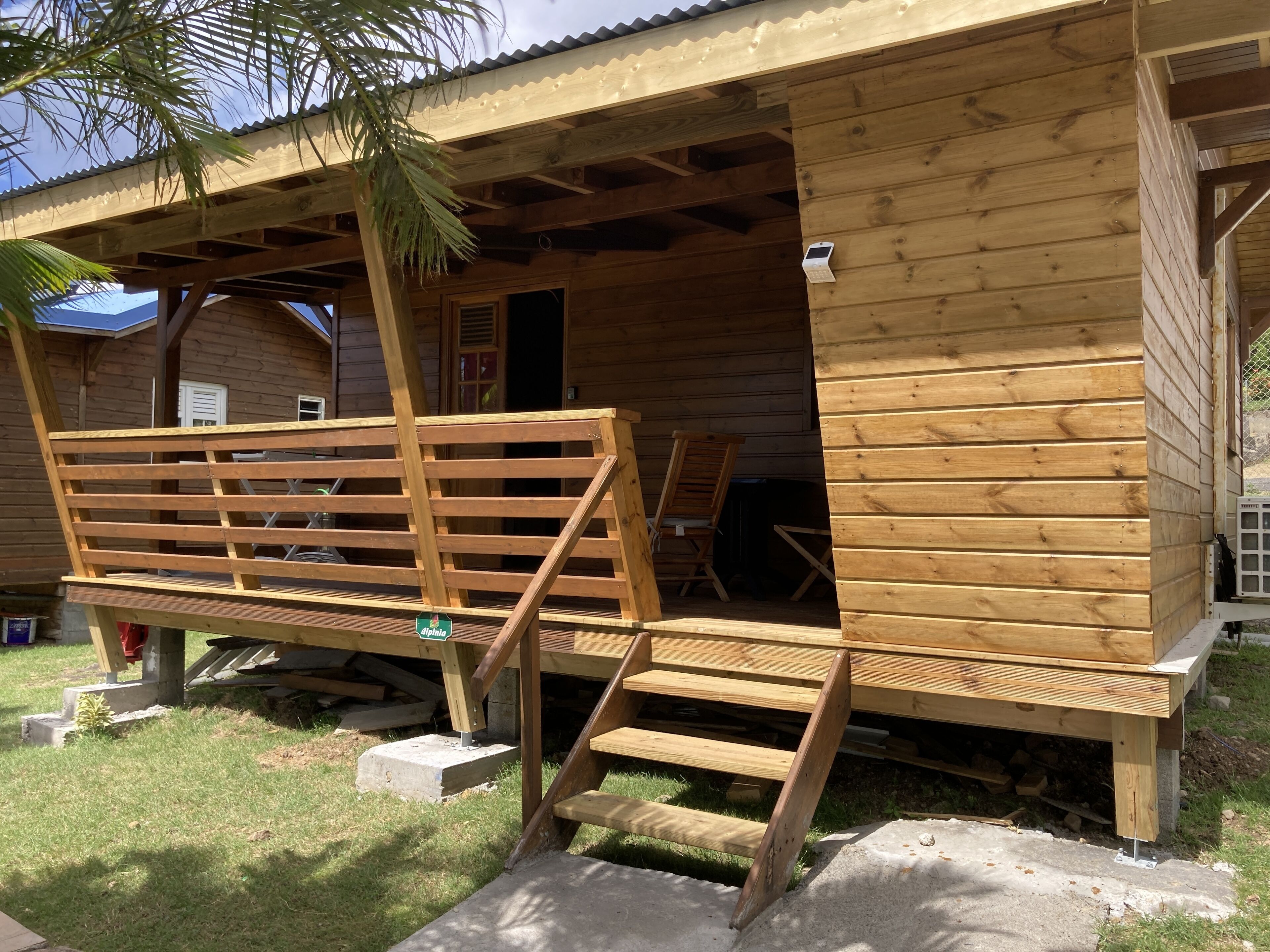A wooden cabin with a porch, a bench, and a small table.