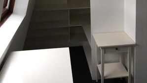 A narrow stairwell with a white wall and a window on the left. There is a small white table at the bottom of the stairs. - Apartment - Sleeps 4 & Excellent Transport Links (London)