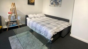 A bedroom with a bed, a ladder, a shelf with books, and two paintings on the wall. - Apartment - Sleeps 4 & Excellent Transport Links (London)
