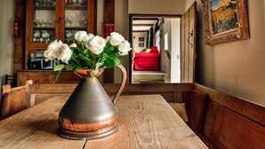 A rustic wooden table with a copper vase holding white roses. - Beili Glas Cottage (Llanfihangel Ystern Llewern)