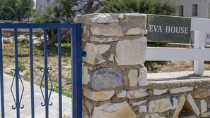 A stone wall with a sign reading "EVA HOUSE" and a blue metal gate. - Cozy and comfortable Cycladic home to enjoy hospitality in Dryos of Paros Island (Paros)