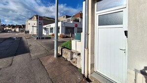 Straßenansicht mit einer weißen Garagentür, einem Gebäude mit der Aufschrift 'CITIZENSHIP' und blauem Himmel.