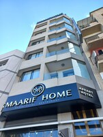 Un edificio de varios pisos con un letrero que dice 'MAARIF HOME APPARTHOTEL - RESTAURANT'.