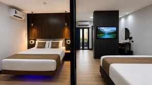 A hotel room with two beds, a TV, a mirror, and an air conditioning unit. - Tuana Hotels The Phulin Resort (Karon)