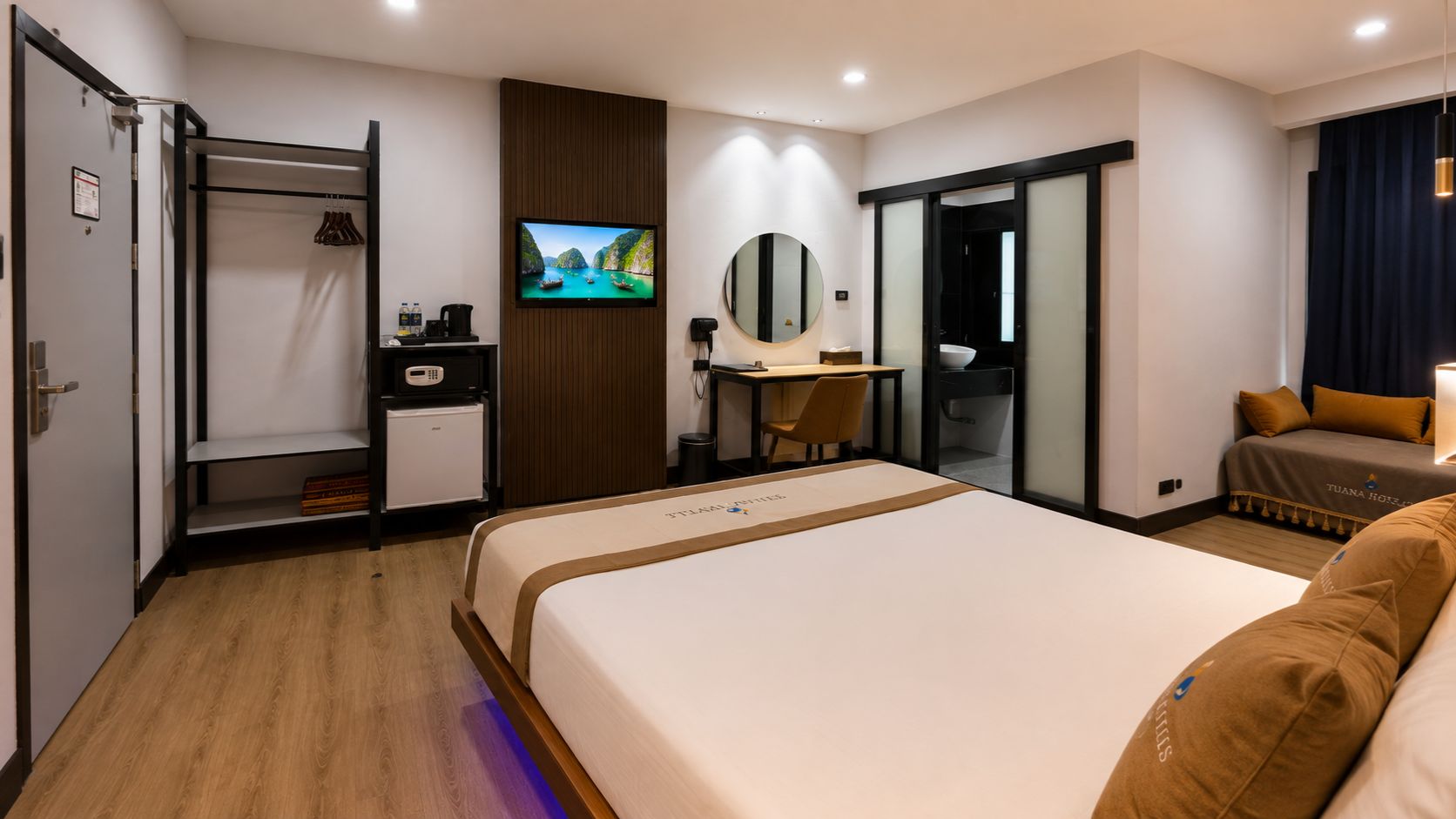 Ein Hotelzimmer mit Bett, Schreibtisch, Fernseher, Kleiderschrank und Bad.