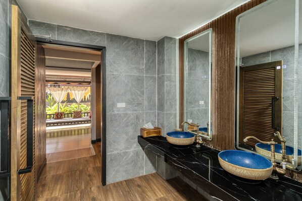 A modern bathroom with two blue ceramic sinks, a large mirror, and a wooden door leading to a balcony. - Tuana Hotels The Phulin Resort (Karon)