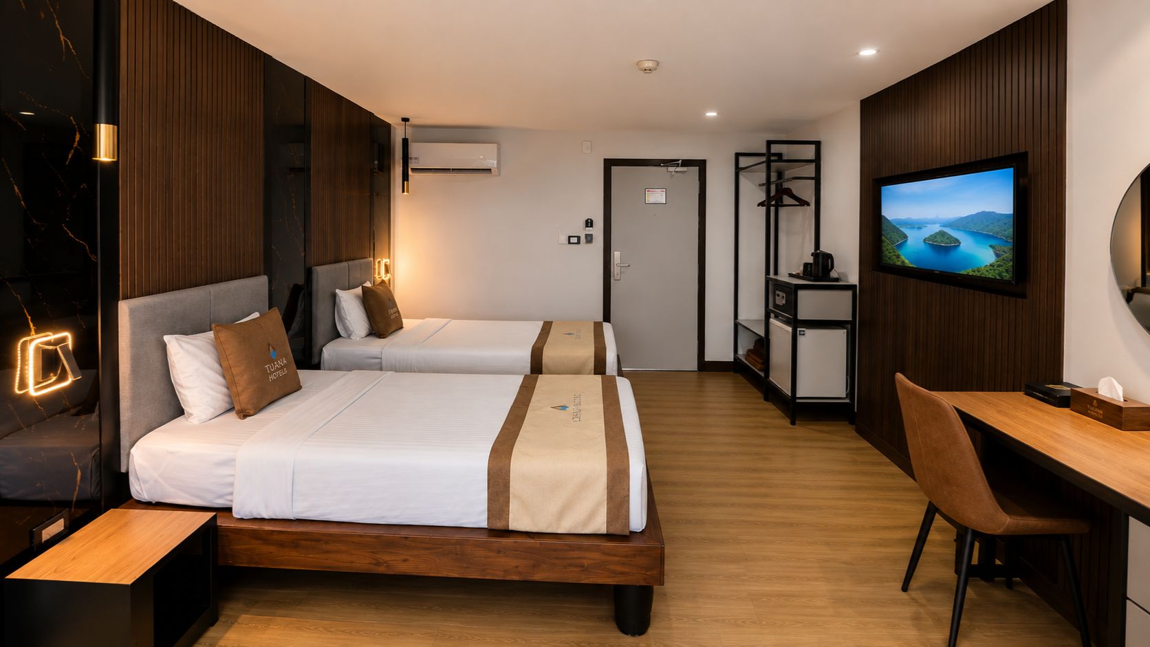 Une chambre d’hôtel avec deux lits, un bureau, une télévision et une armoire.