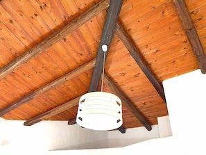 A wooden ceiling with exposed beams and a white hanging light fixture. - Villa Rosa dei Venti (Valledoria)