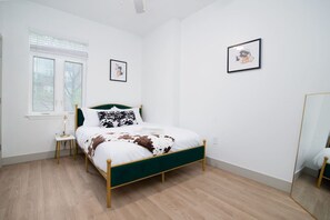 Cozy retreat with a single bed, bedside table, and framed artwork.