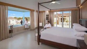 Ein geräumiges Schlafzimmer mit einem großen Bett, einem Balkon und Blick auf die Umgebung.