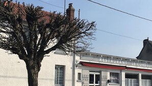 Rakennuksessa on kyltti, jossa lukee ”RESTAURANT LE CORDELIER”, ja sen edessä on puu.