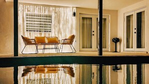 A modern outdoor seating area with a pool reflecting the surroundings.