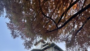 Una casa a due piani con fondamenta in pietra, un portico avvolgente e una finestra a bovinda.