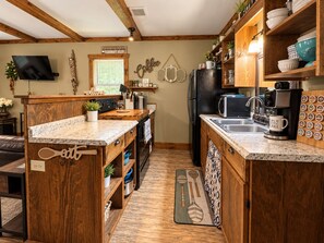 A kitchen with wooden cabinets, a built-in oven, a coffee maker, and a refrigerator. - FAST WI-FI Sardis Lake Cabin (Como)