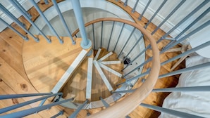 A spiral staircase with wooden steps and metal railings.
