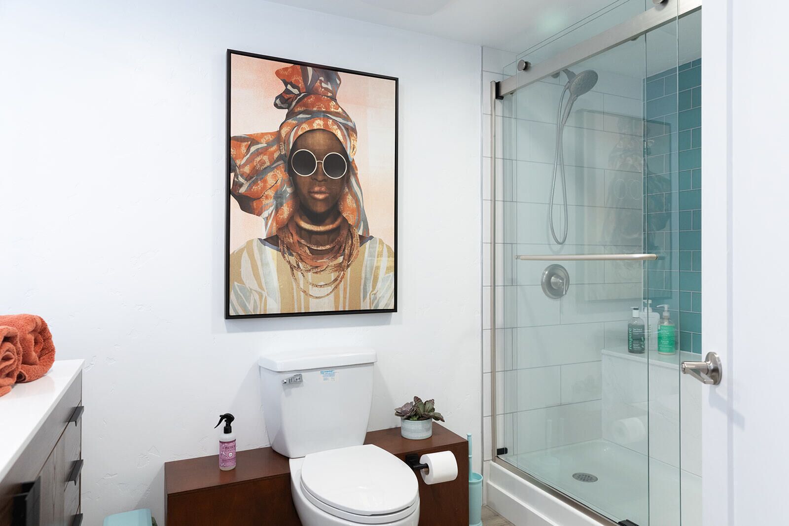 A modern bathroom with a glass shower enclosure, a toilet, and a sink with a towel on the counter.