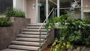 Una escalera con barandales de metal que conduce a una puerta de vidrio.